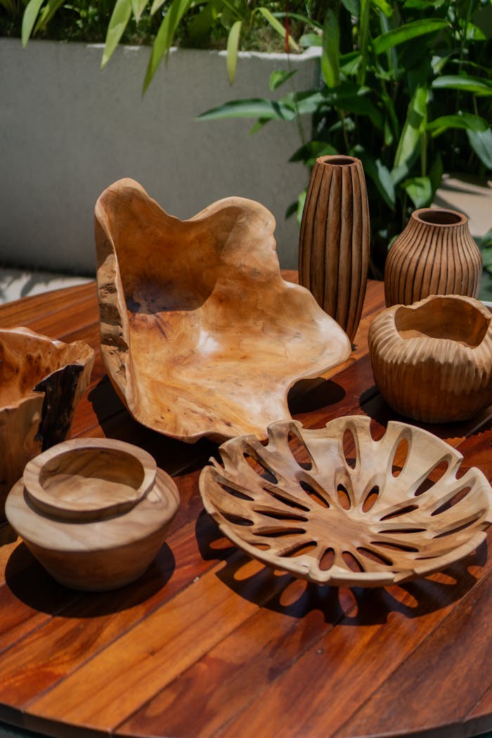 about-01 Artistic wooden bowls and vases arranged on a table outdoors, showcasing craftsmanship.